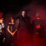 Carmeria band photo in gothic costume on a red lit stage