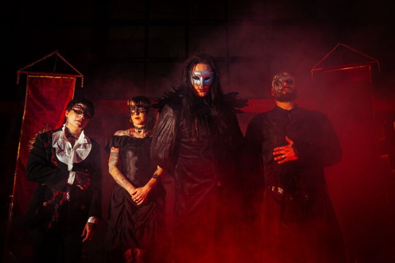 Carmeria band photo in gothic costume on a red lit stage