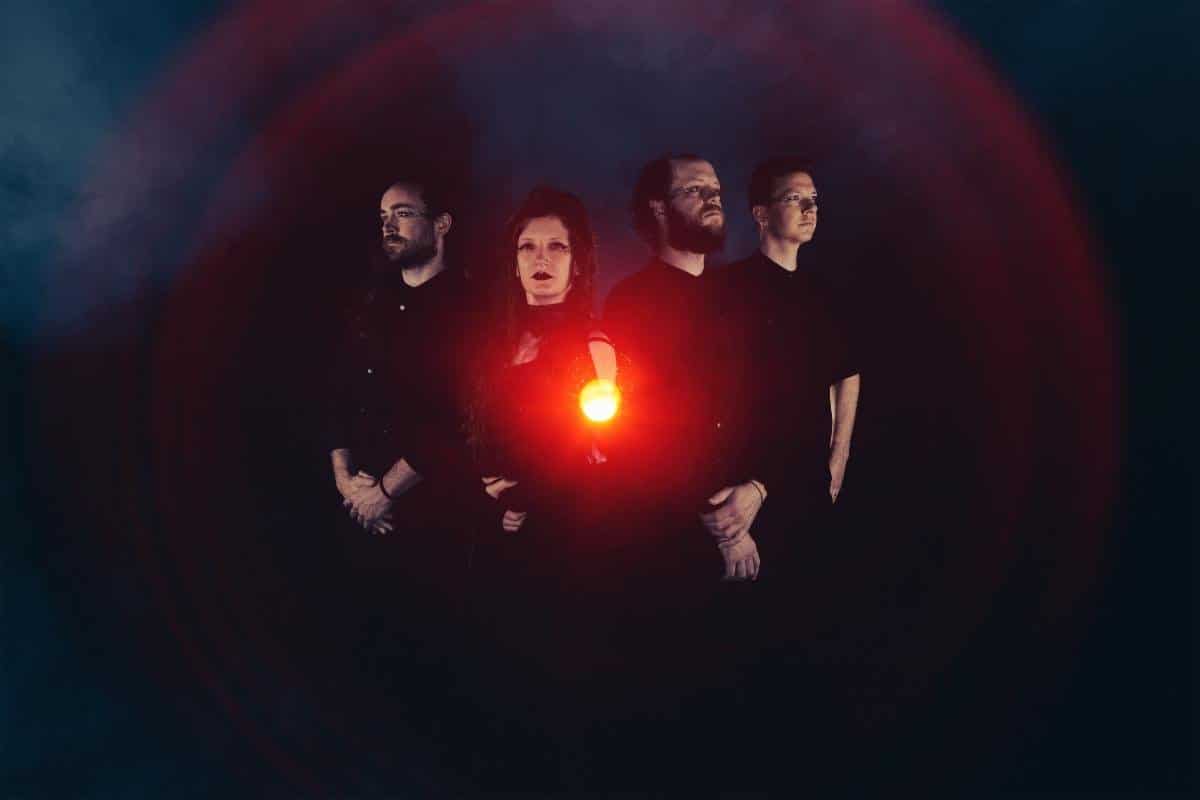 Dreadnought band photo with the four members in the dark around a red light